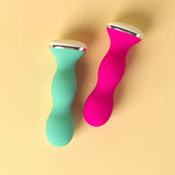 Two Perifit Kegel Exercisers—smart, silicone pelvic floor trainers in teal and pink—lie side by side on a light yellow background, each featuring curved shapes with silver and white accents at the ends.