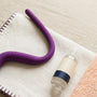 Intimate Rose pelvic wand on a folded cloth beside water-based lubricant, set up for at-home pelvic floor release