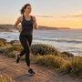 Woman running on a coastal path at sunrise, leaking when running is common and treatable
