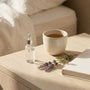 Bedside table with skincare products, a mug and a book — menopause lubricant guide from Blossom Pelvic Health