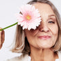 A lady going through the signs of menopause holding a flower.