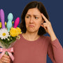 Woman holding a bouquet of flowers with colourful silicone vaginal dilators tucked among the blooms, unsure where to start