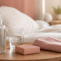 Bottle of water-based lube, a condom box and a glass of water on a bedside table in soft morning light