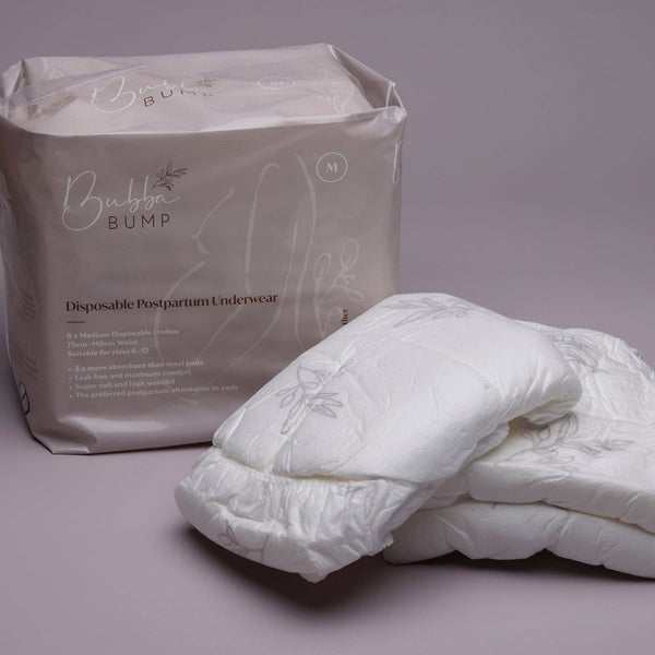 The Bubba Bump Disposable Postpartum Underwear package, featuring floral designs, offers leak-proof protection. An array of unfolded white underwear sits next to the package on a gray background.
