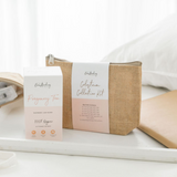 A neatly arranged setup featuring a box of Pregnancy Tea and a pouch of The Breastfeeding Tea Co Antenatal Colostrum Collection Kit on a white surface. The items, ideal for antenatal expression, are set against a soft, natural light background, evoking a calm and serene atmosphere.