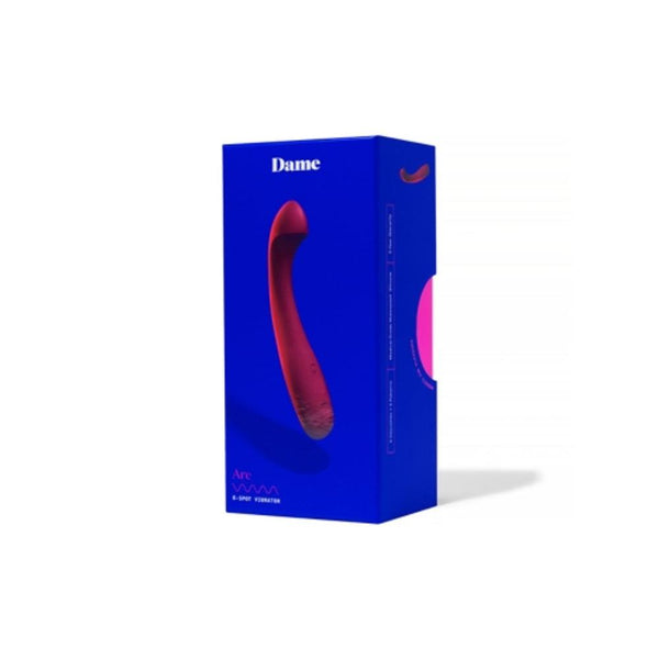 Packaged in an elegant blue box with "Dame" branding, the red Arc vibrator is prominently displayed. The minimalist packaging emphasizes its medical-grade silicone and versatility for G-spot stimulation, while detailed product information on the side highlights its clitoris-stimulating features.