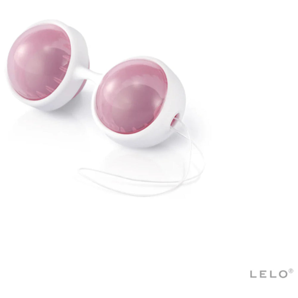 A pair of white and pink silicone LELO Beads Plus Pleasure Set Kegel balls with a connecting stem and retrieval cord, ideal for pelvic floor training or Ben Wa use, shown on a white background with the LELO logo in the bottom right corner.