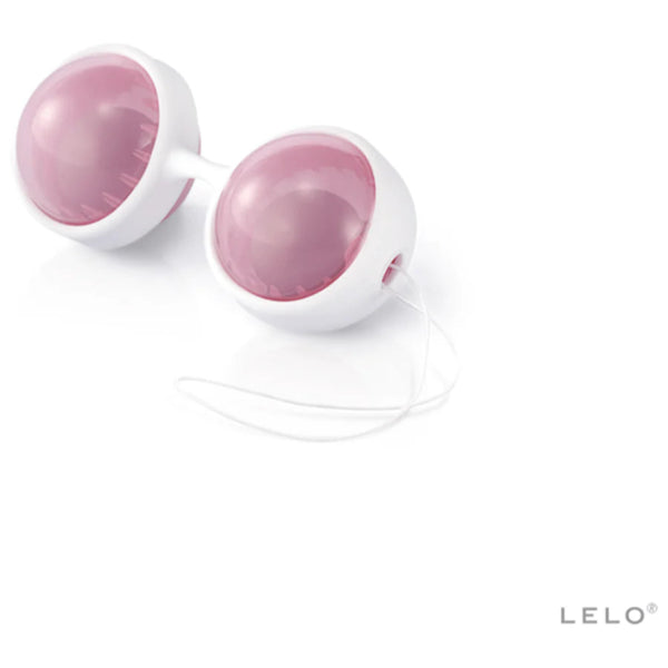 A pair of white and pink silicone LELO Beads Plus Pleasure Set Kegel balls with a connecting stem and retrieval cord, ideal for pelvic floor training or Ben Wa use, shown on a white background with the LELO logo in the bottom right corner.