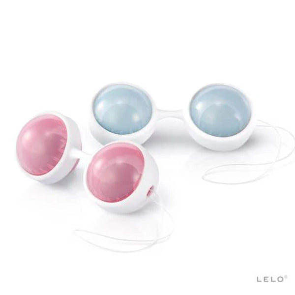 Two pairs of LELO Luna Beads Classic (by LELO): pink and blue kegel exercise balls in white holders with retrieval strings, designed to strengthen the pelvic floor. The LELO logo appears at the bottom right.