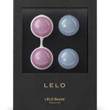 The LELO Luna Beads Classic by LELO includes four round beads—two pink, two blue—and a white silicone holder in sleek black packaging, perfect as a Kegel exercise aid and for enhancing pelvic floor strength.