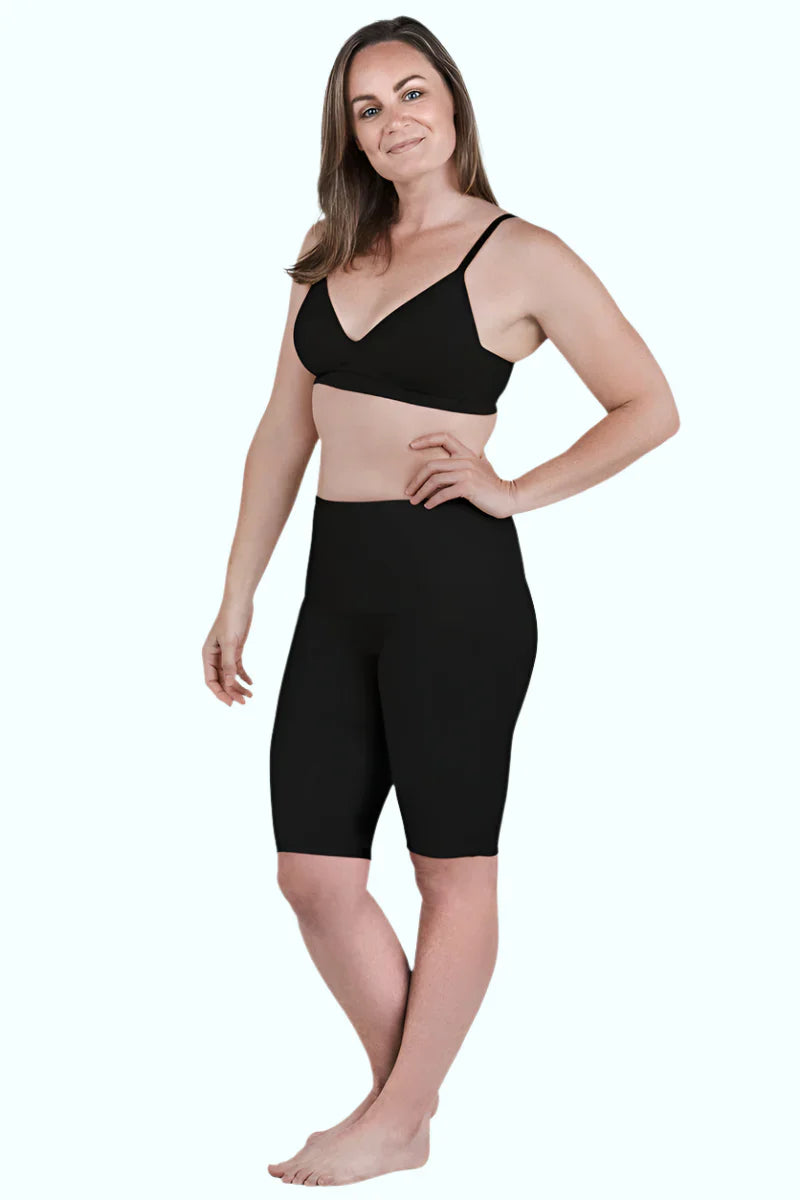 Woman wearing black SRC Restore knee-length compression shorts, front view