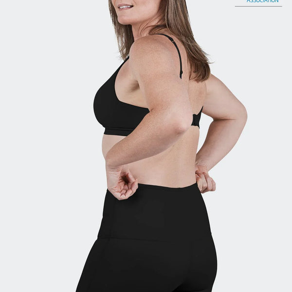 Woman wearing black SRC Restore Mini compression shorts, front view