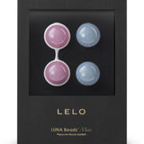 A black box with a clear window displays LELO Luna Beads Mini by LELO—Kegel exercisers with two pink beads in a white holder and two blue beads, ideal for pelvic floor strengthening. Gold text reads 