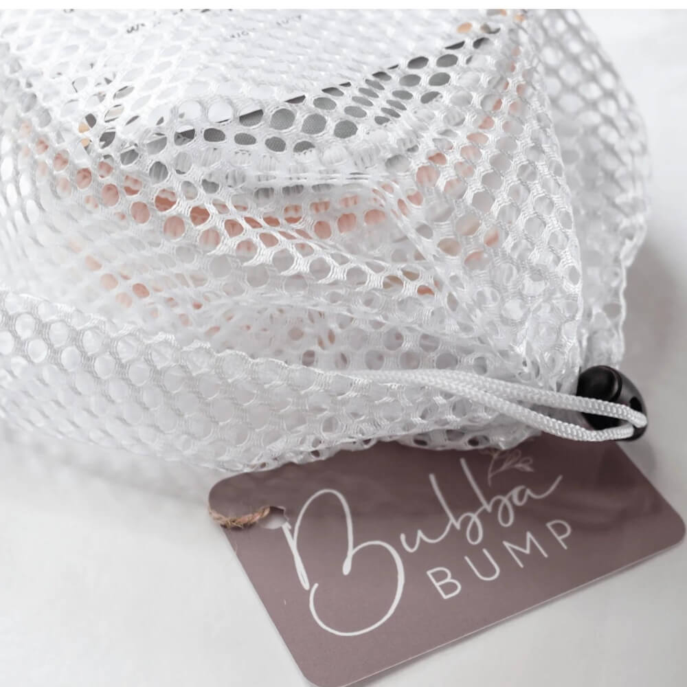 A white mesh laundry bag with a black drawstring is shown. Attached to the string is a brown tag that has "Bubba Bump" written on it in white cursive font. Perfect for storing Bubba Bump's Organic Bamboo Reusable Breast Pads - 14 Pack, the bag appears to be empty and is neatly arranged.