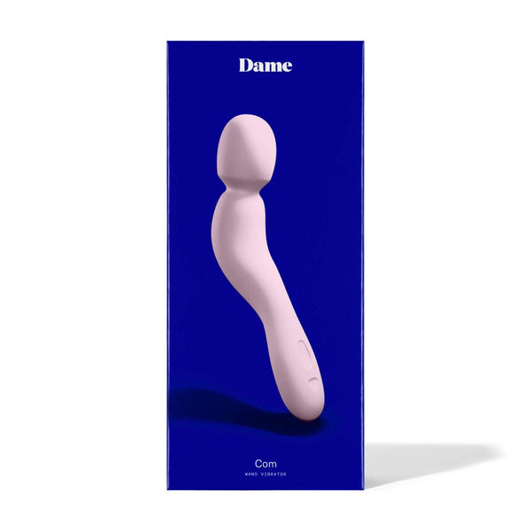 The Dame Com - External Wand Vibrator by Dame is beautifully presented against a blue background, featuring a light pink wand design that offers rumbly vibrations and a flexible neck for enhanced comfort and satisfaction.