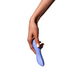 A hand holding the Dame Dip 2.0 - Basic Vibrator by Dame against a white background. Crafted from medical-grade silicone, this sleek, blue vibrator features a smooth, curved design for enhanced clitoral stimulation.