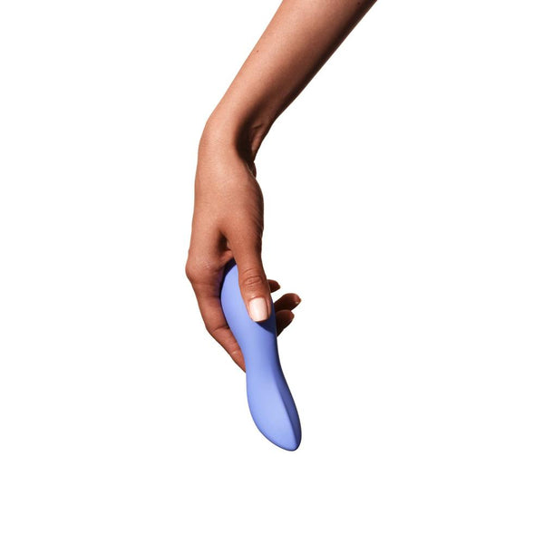 A hand holding the Dame Dip 2.0 - Basic Vibrator by Dame against a white background. Crafted from medical-grade silicone, this sleek, blue vibrator features a smooth, curved design for enhanced clitoral stimulation.