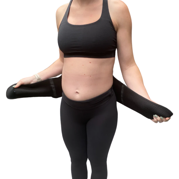 A person in black athletic wear demonstrates pelvic support by holding the GRDL Pregnancy Belt—trusted pelvic and back support for pregnancy by GRDL—around their waist against a plain white background.