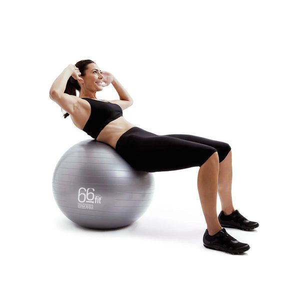 A woman performing a sit-up on a gym ball, engaging her core muscles and balancing on the ball.