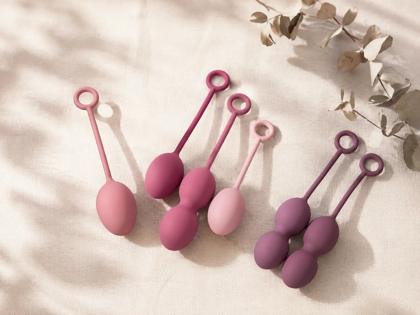 Multiple kegel ball sets in soft pink and rose silicone on cream linen — choosing the right kegel weights for pelvic floor training in Australia