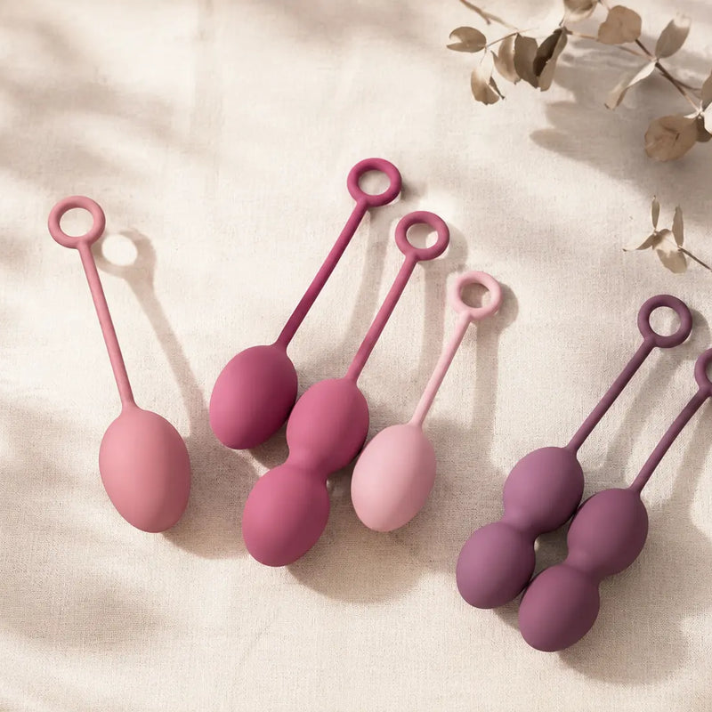 Multiple kegel ball sets in soft pink and rose silicone on cream linen — choosing the right kegel weights for pelvic floor training in Australia