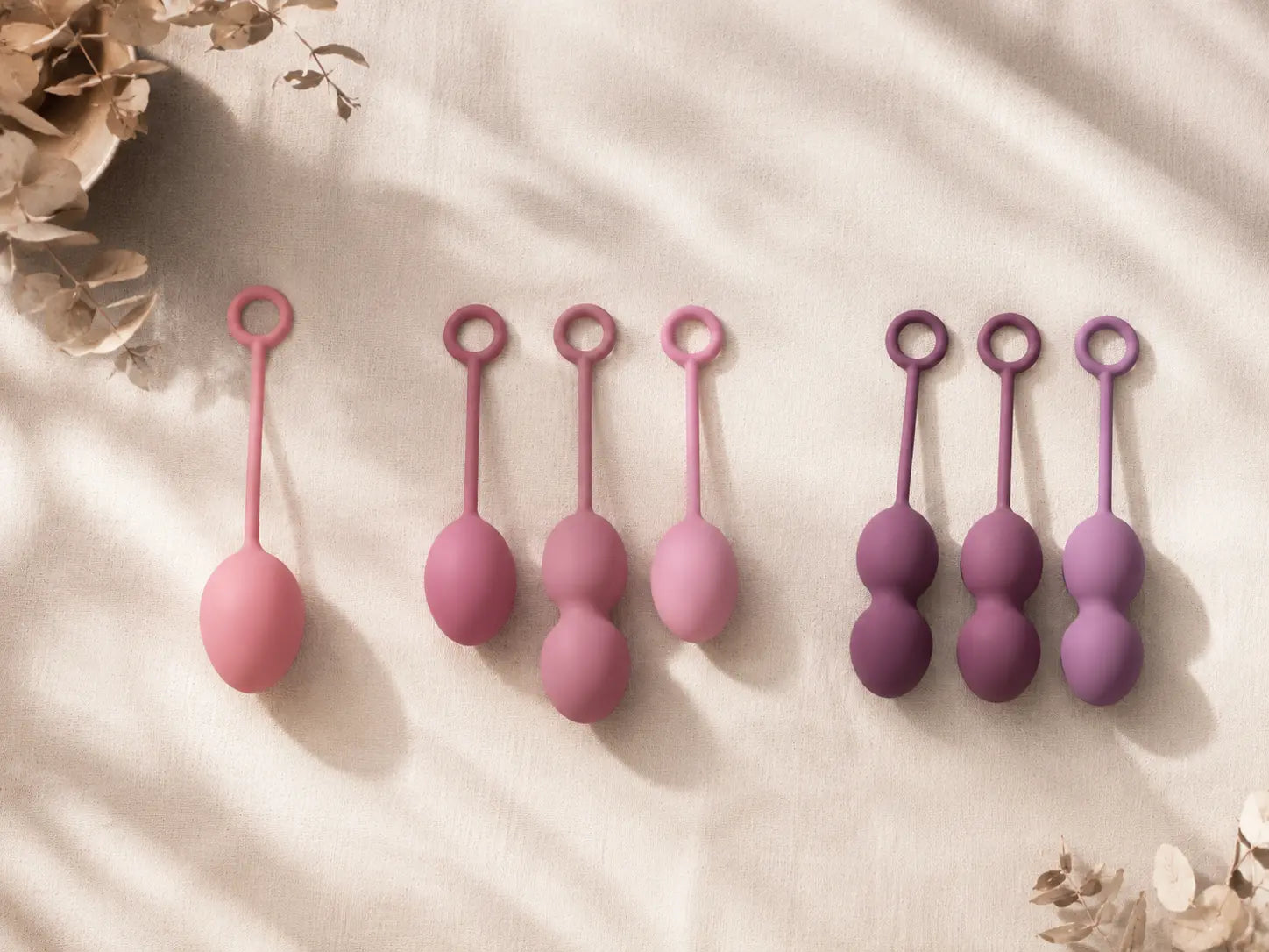 Kegel ball progression from beginner single ball to advanced multi-ball weighted sets in pink and purple silicone — pelvic floor training tools