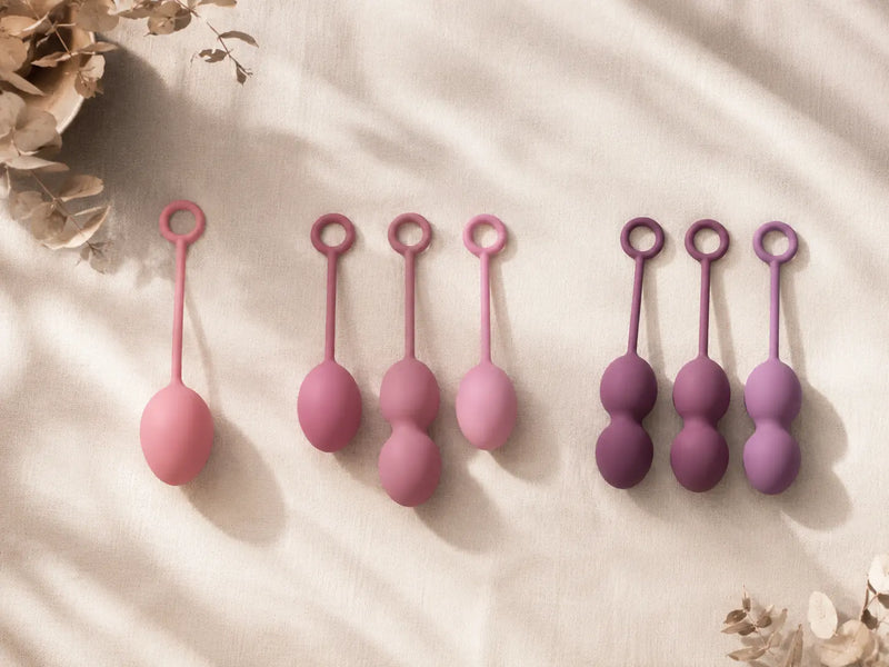 Kegel ball progression from beginner single ball to advanced multi-ball weighted sets in pink and purple silicone — pelvic floor training tools
