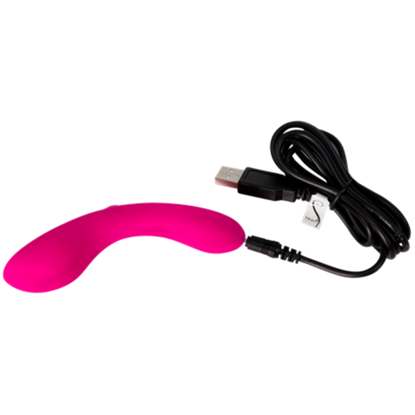 The Mini Swan Wand, a bright pink curved G spot vibrator with a smooth surface, lies next to a black USB charging cable.
