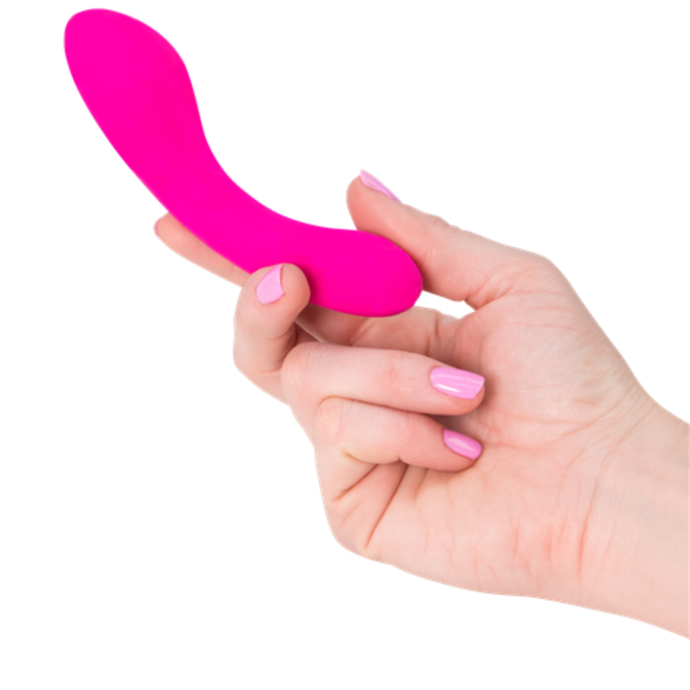 A hand with pink-painted nails holds a small, curved, pink silicone The Mini Swan Wand by Swan. The background is white.