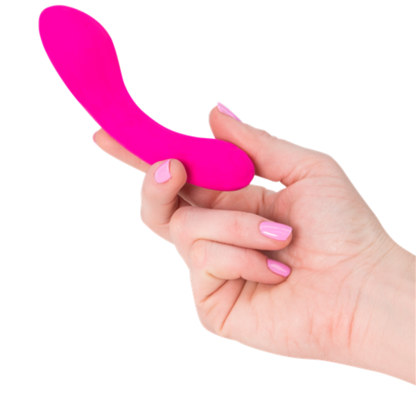 A hand with pink-painted nails holds a small, curved, pink silicone The Mini Swan Wand by Swan. The background is white.