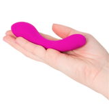 A hand holds a small, curved, pink Mini Swan Wand by Swan with two bulbous ends—an elegant waterproof G-spot vibrator.