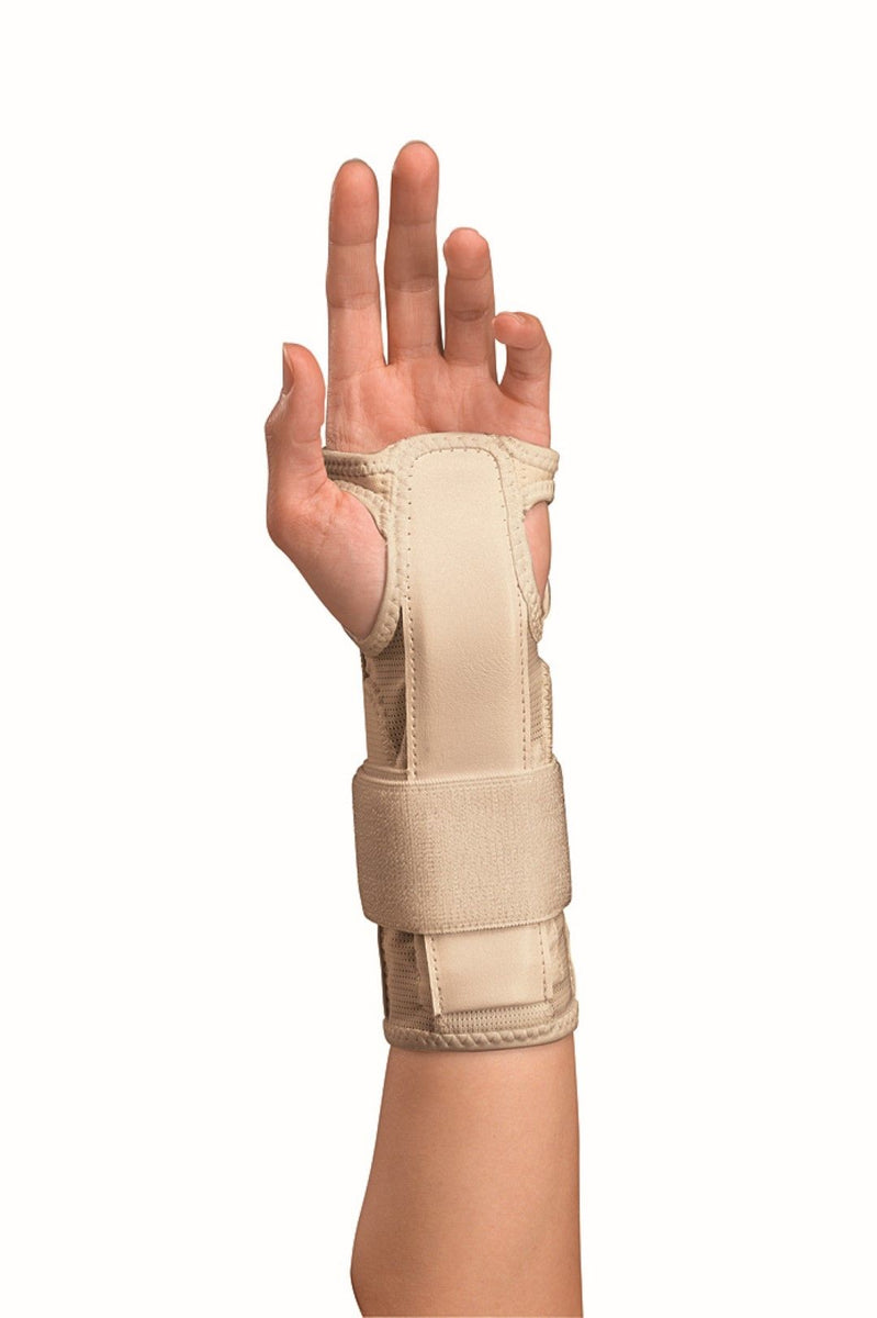 A left hand wearing a Mueller Carpal Tunnel Wrist Brace in beige. The adjustable brace has two straps for support and immobilization, extending from the mid-palm to the mid-forearm to provide pain relief and prevent movement. The palm is facing forward, with fingers extended.