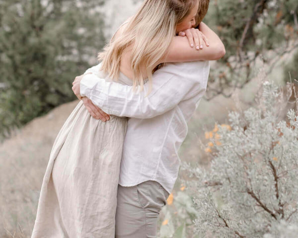 A couple embraces outdoors in soft daylight — relaxed, comfortable intimacy after introducing Ohnut depth-limiting rings into their routine. Lifestyle imagery for the Ohnut Australia review on Blossom Pelvic Health.