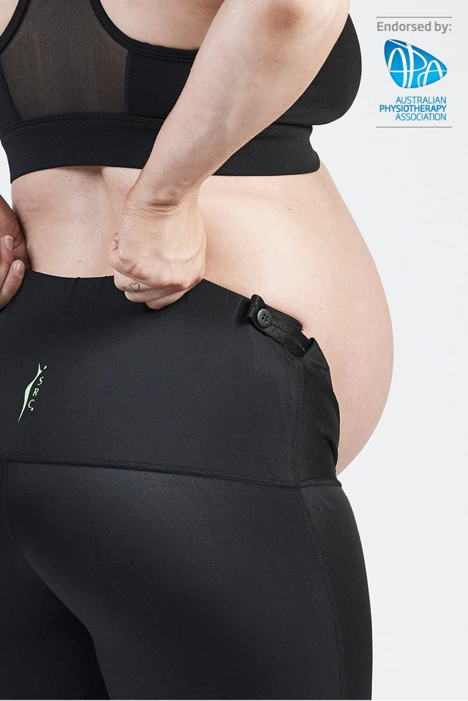 A close-up of a pregnant person wearing the SRC Maternity Shorts from SRC Health. They adjust the waistband that provides pelvic support, with a visible endorsement by the Australian Physiotherapy Association in the top right corner, highlighting low back pain relief during pregnancy.